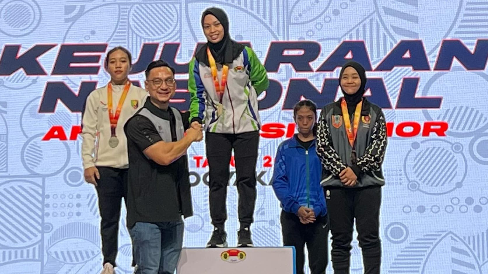 Riska Nur Amanda saat naik podium di Kejurnas Angkat Besi Senior 2025 di GOR UNY Yogyakarta. Meski belum pulih 100%, ia sukses raih medali perunggu untuk Kalimantan Selatan.(dok PABSI Kalsel)