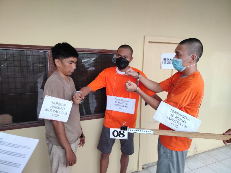 KAKAK BERADIK: Kedua tersangka, Rizki Al-Husaini (26) dan Ridho Saputra (24) mereka ulang adegan pengeroyokan yang menewaskan Akhmad Mulyadi (32).