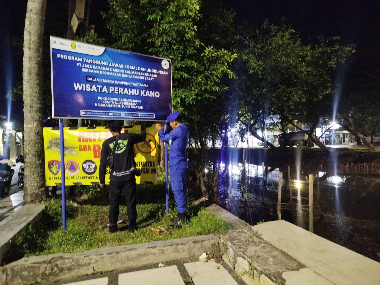 WASPADA: Polisi dan BPBD Banjarmasin memasang spanduk peringatan larangan beraktivitas di sekitar Sungai Jafri Zam-Zam, Senin (26/5/2025). Riyad Dafhi Rizki/Radar Banjarmasin.