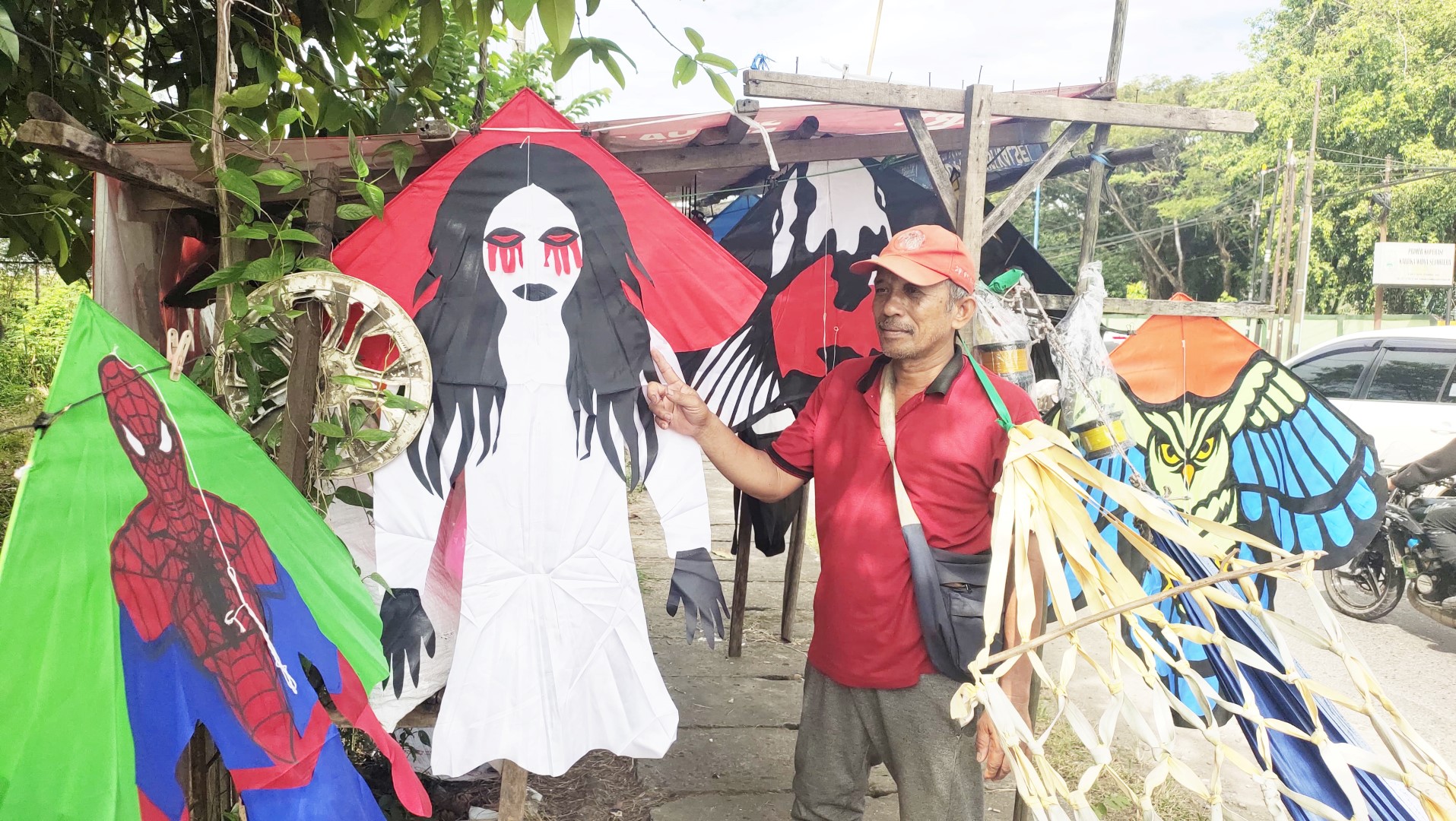 ANEKA LAYANGAN: Joko Purnomo menunjuk layangan bertema horor di lapak jualannya di Jalan Ahmad Yani Kilometer 25, Landasan Ulin, Banjarbaru, Kamis (29/5) siang.