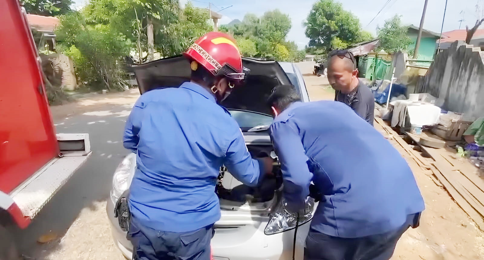 SERBA BISA: Petugas Damkar Banjarbaru saat melakukan proses jumper terhadap aki mobil milik Bawai yang mogok, Rabu (28/5).