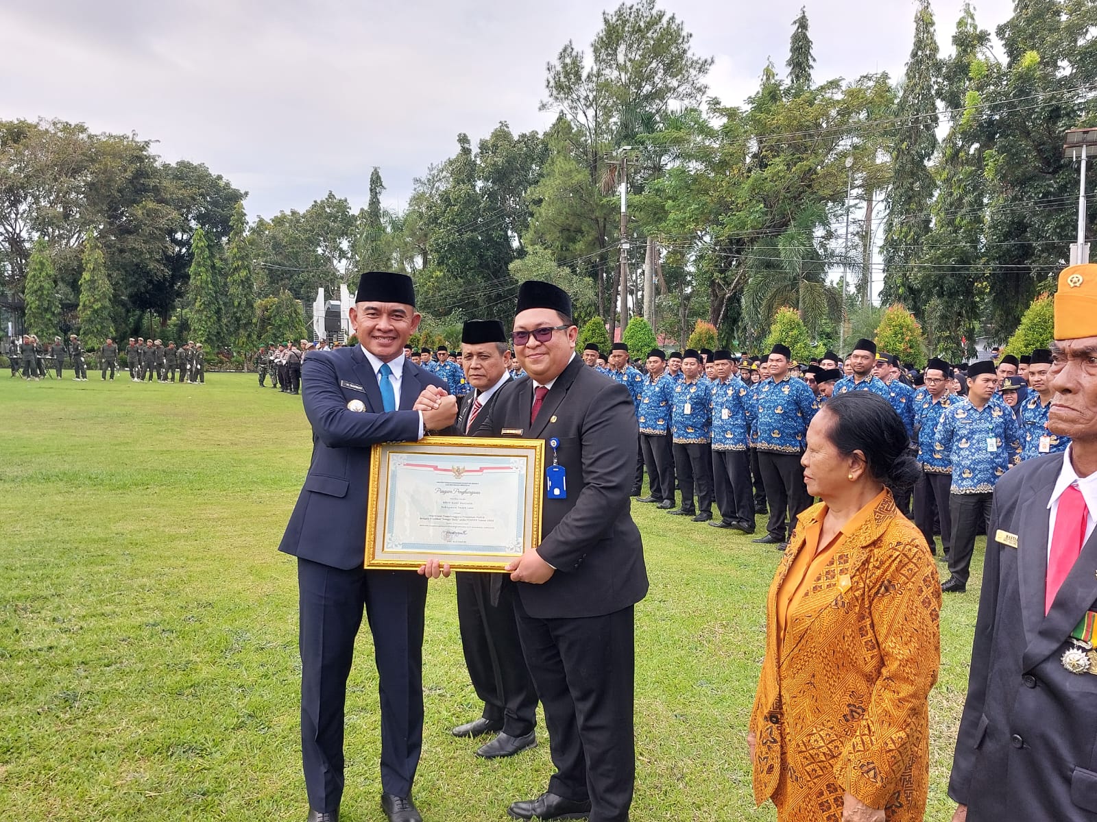 PRESTASI:Bupati Tala, H Rahmat Trianto menyerahkan piagam penghargaan pelayanan publik kepada Direktur RSUD Hadji Boejasin, drg Budi Rukhiyat saat apel gabungan.(Foto:Norsalim Yahya/Radar Banjarmasin)