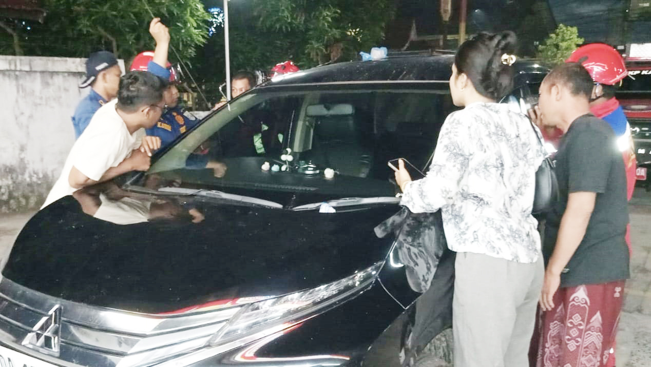 EVAKUASI: Tim gabungan dari UPT Damkar Banjarbaru dan DPKP Banjar berupaya mengevakuasi balita yang terkunci di dalam mobil, Sabtu (31/5) sore.