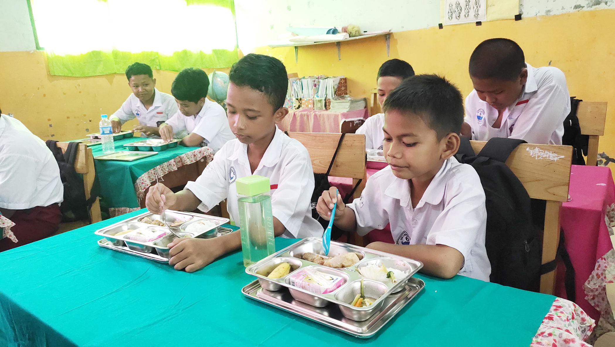 MENIKMATI: Para siswa SDN 4 Sungai Ulin menikmati sajian makanan bergizi gratis saat diluncurkan, Senin (2/6).