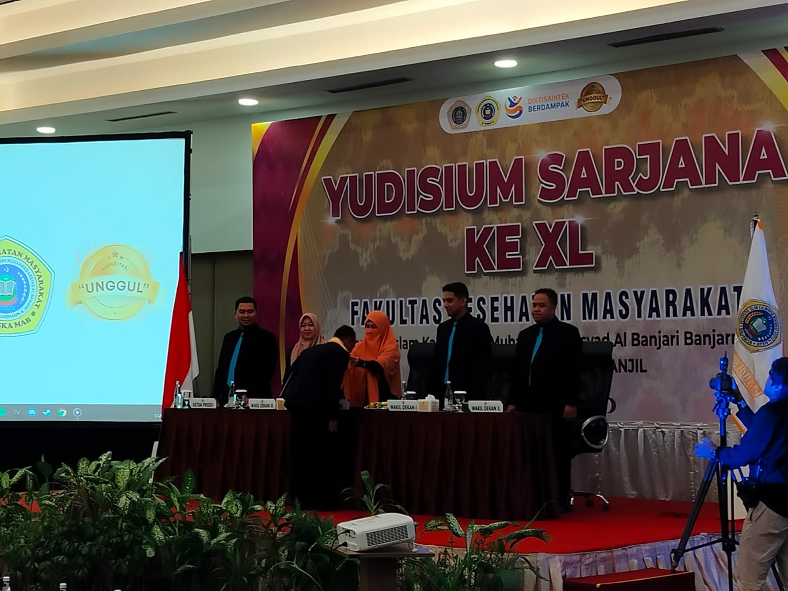 TANDA LULUS:Dekan FKM UNISKA, Meilya Farika Indah mengalungkan gordon kepada lulusan Uniska yudisium 2024/2025 di Rattan Inn Banjarmasin, Selasa (3/6/2025).(Foto:Maulana/Radar Banjarmasin)