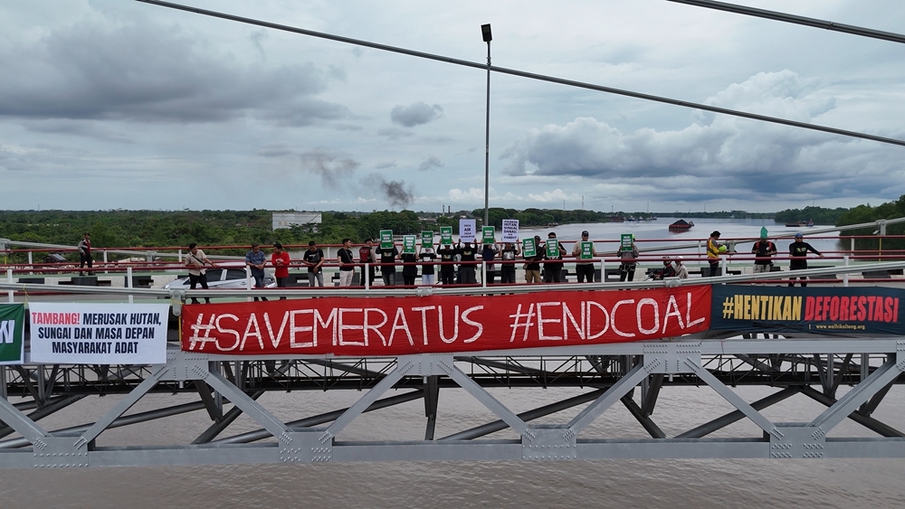 PROTES: Para aktivis Walhi dari Kalimantan Selatan dan Tengah menggelar aksi protes di Jembatan Barito, Ahad (1/6). (Walhi Kalsel untuk Radar Banjarmasin)