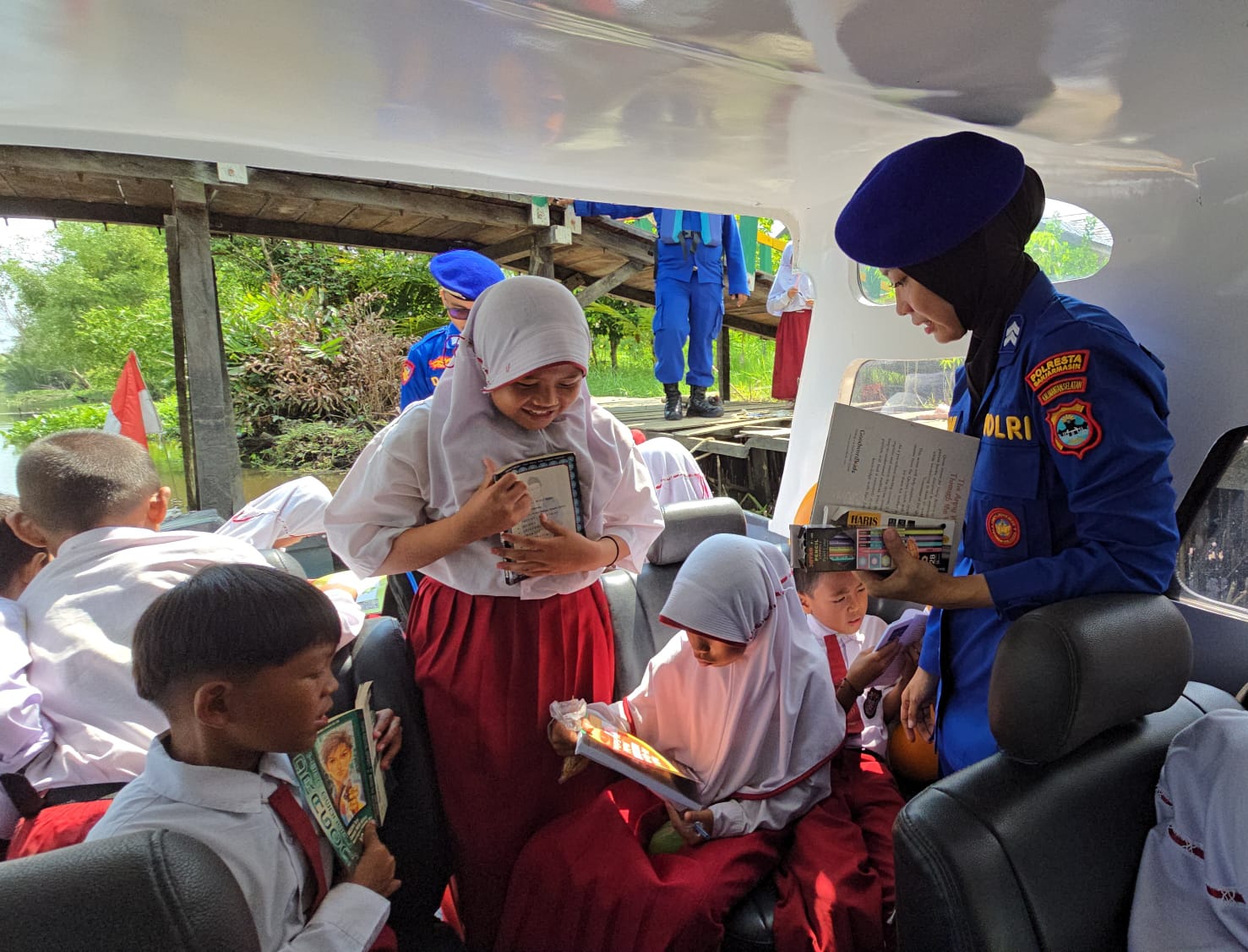 KAPAL PATROLI: Siswa dan siswi SDN Basirih 10 ini antusias membaca buku di Perpustakaan Terapung milik Polresta Banjarmasin. (Foto: Polairud Polresta Banjarmasin)