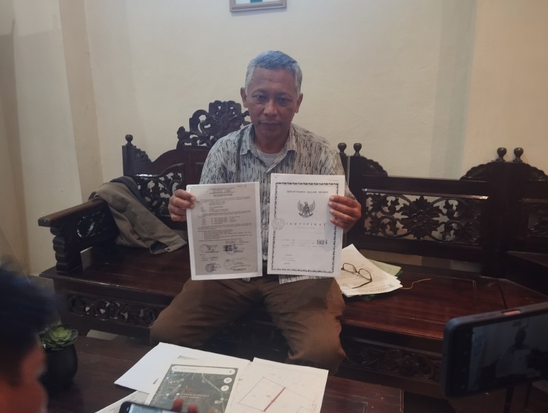 PUNYA BUKTI: Leonardo menunjukkan dua surat kepemilikan tanah yang menurutnya janggal, usai sidang perdata di PN Martapura.