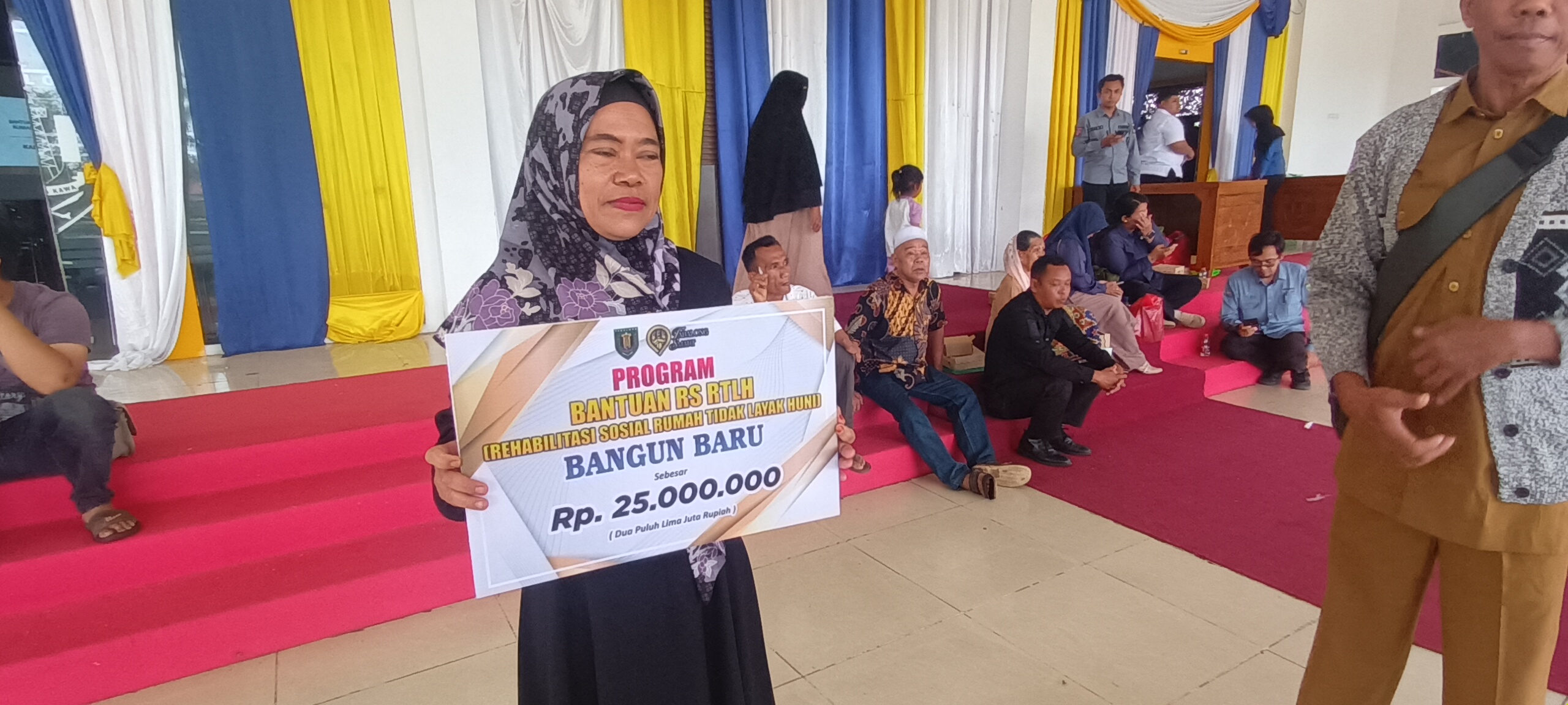 TERIMA BANTUAN : Tri Kusumawati melihatkan bantuan uang yang diterimanya dari Dinsos Tabalong  (Foto : Ibnu Dwi Wahyudi)