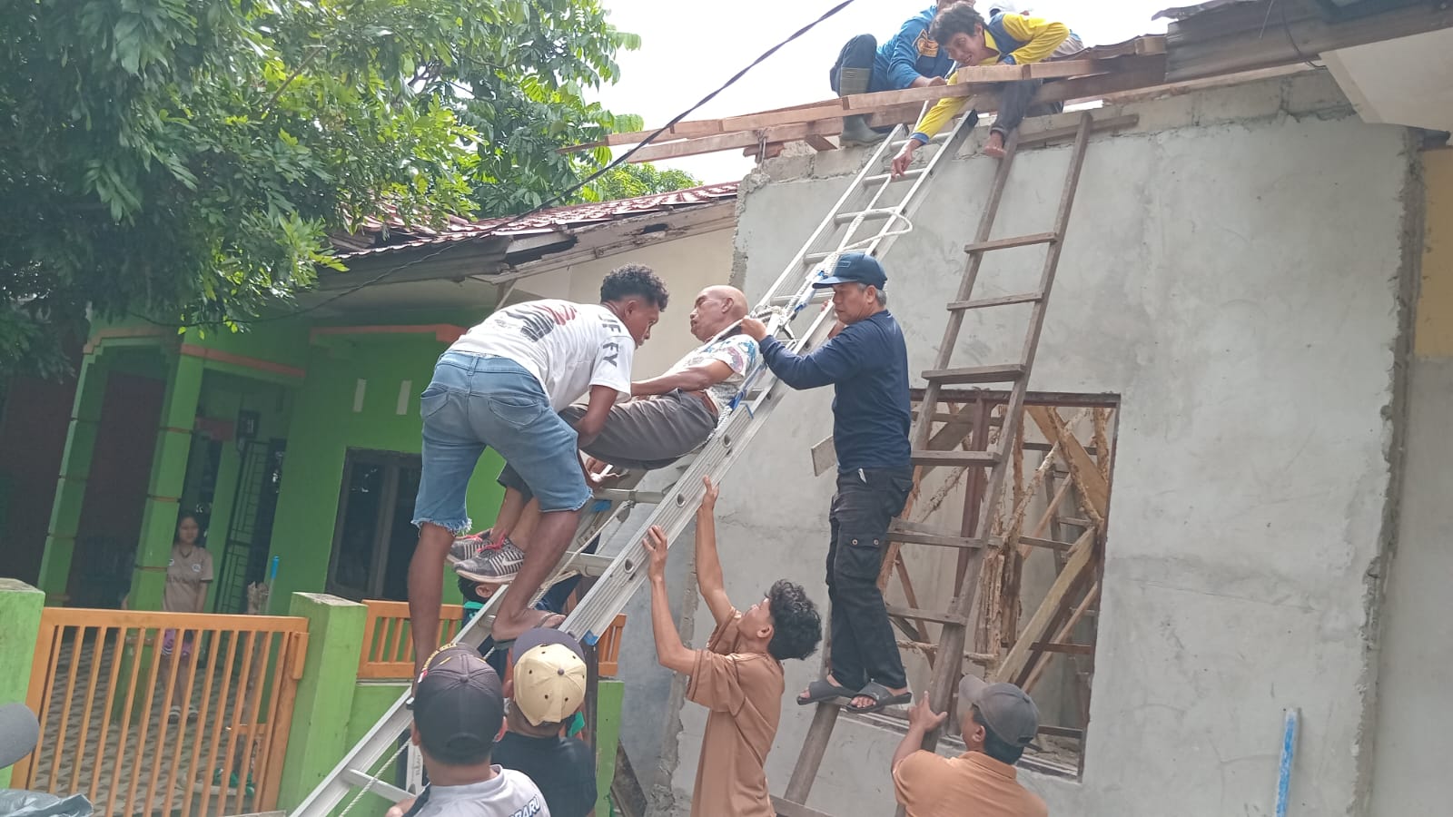 EVAKUASI: Petugas Damkar Banjarbaru saat melakukan evakuasi pekerja bangunan yang pingsan di atas atap (Damkar Banjarbaru untuk Radar Banjarmasin)