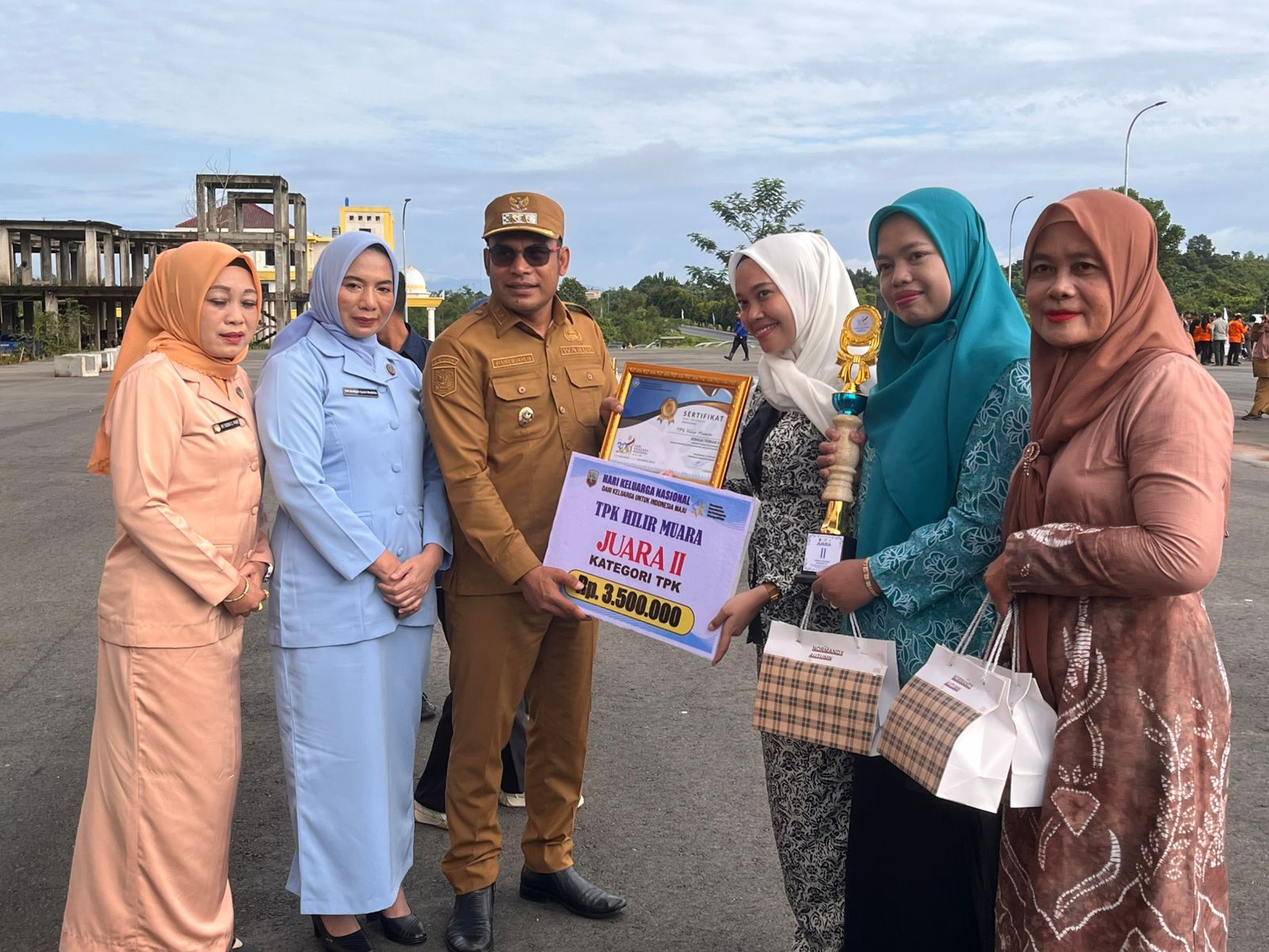 SENANG: Bersam istri, Wabup Syairi Mukhlis menyerahkan piala dan penghargaan untuk TPK Hilir Muara.(Foto:Diskominfo Kotabaru)
