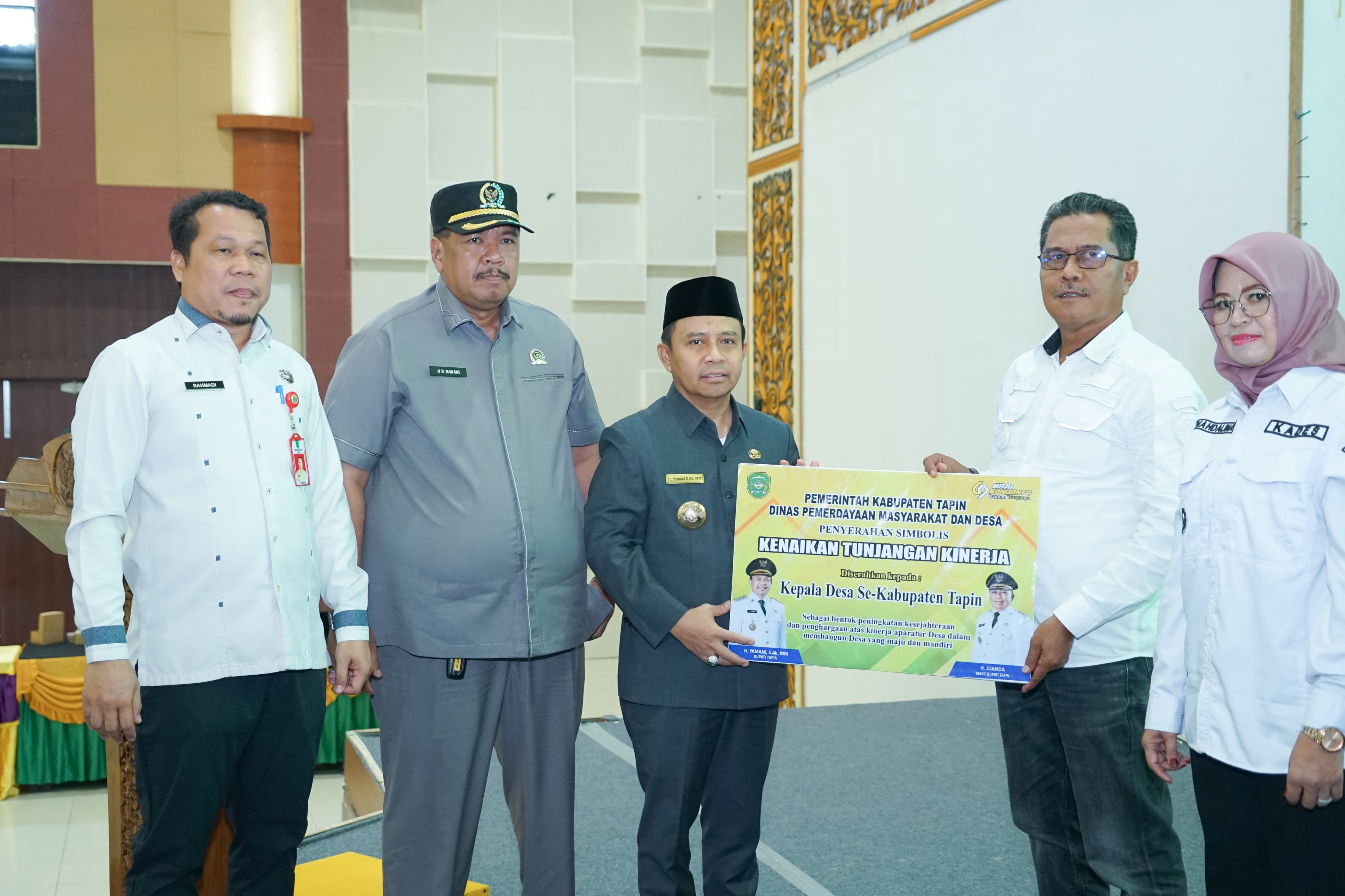 NAIK: Bupati Tapin H Yamani secara simbolis menyerahkan kenaikan tunjangan untuk perangkat desa se-Kabupaten Tapin. (Foto: Prokopim Setda Tapin)