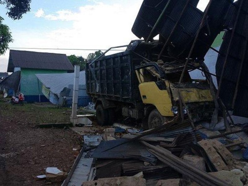 SERUDUK: Inilah penampakan truk yang menyeruduk tiga bangunan di tepi Jalan Ahmad Yani, Desa Gunung Raja, Kecamatan Tambang Ulang, Selasa (1/7). (Foto : Grup R2T untuk Radar Banjarmasin)