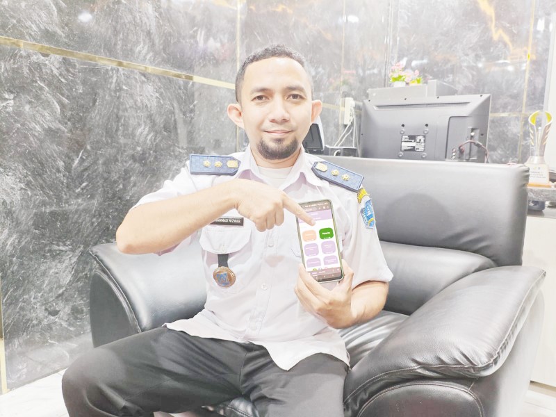 APLIKASI: Lurah Kandangan Utara Muhammad Nizwar menunjukkan aplikasi Pacarku. (Foto Salahudin/Radar Banjarmasin)