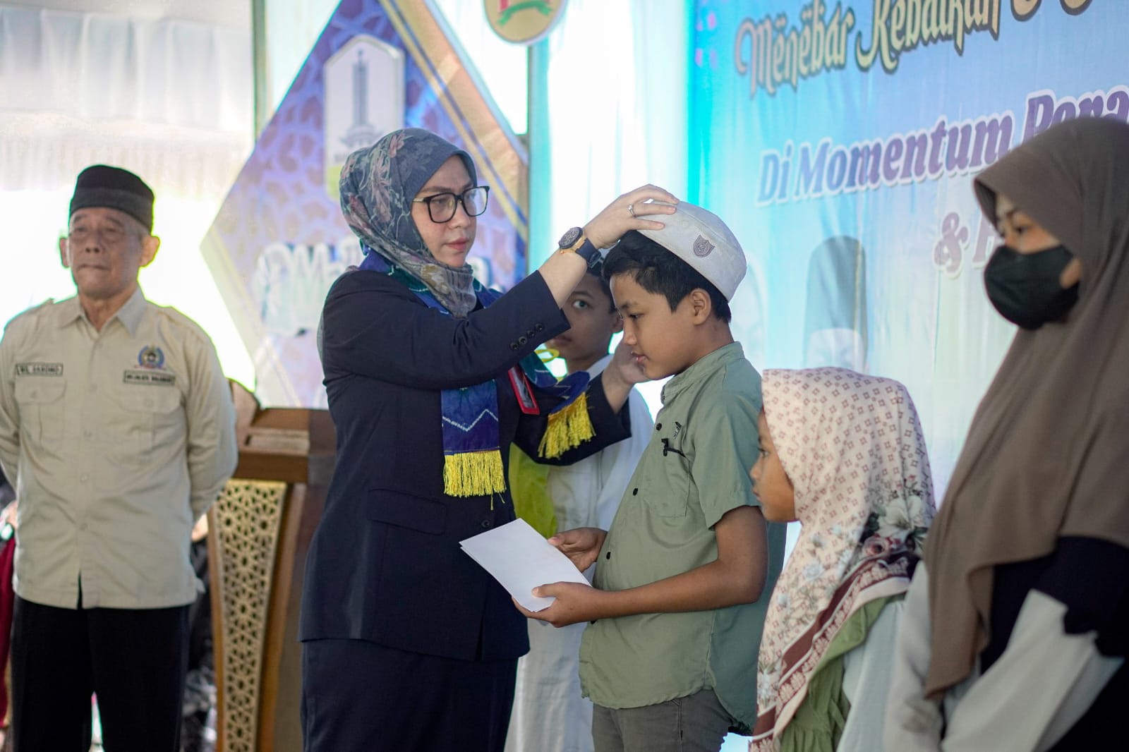 PERHATIAN:Wali Kota Banjarbaru, Hj Erna Lisa Halaby mengusap kepala anak yatim piatu di momen 10 Muharram.(Foto:MC Banjarbaru untuk Radar Banjarmasin)