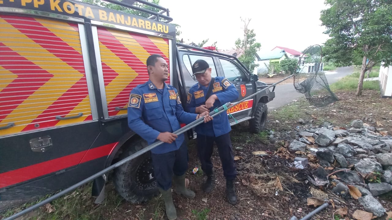 DIMINTA MENYELAMATKAN: Petugas Damkar Banjarbaru melakukan evakuasi kucing yang tercebur ke sumur. (Foto: Damkar Banjarbaru untuk Radar Banjarmasin)