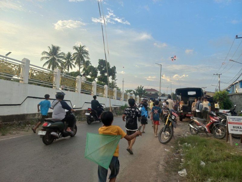 BERLARIAN: Anak kecil dan remaja berlarian mengejar layang-layang putus di Jembatan Patih Masih, Rabu (9/7).