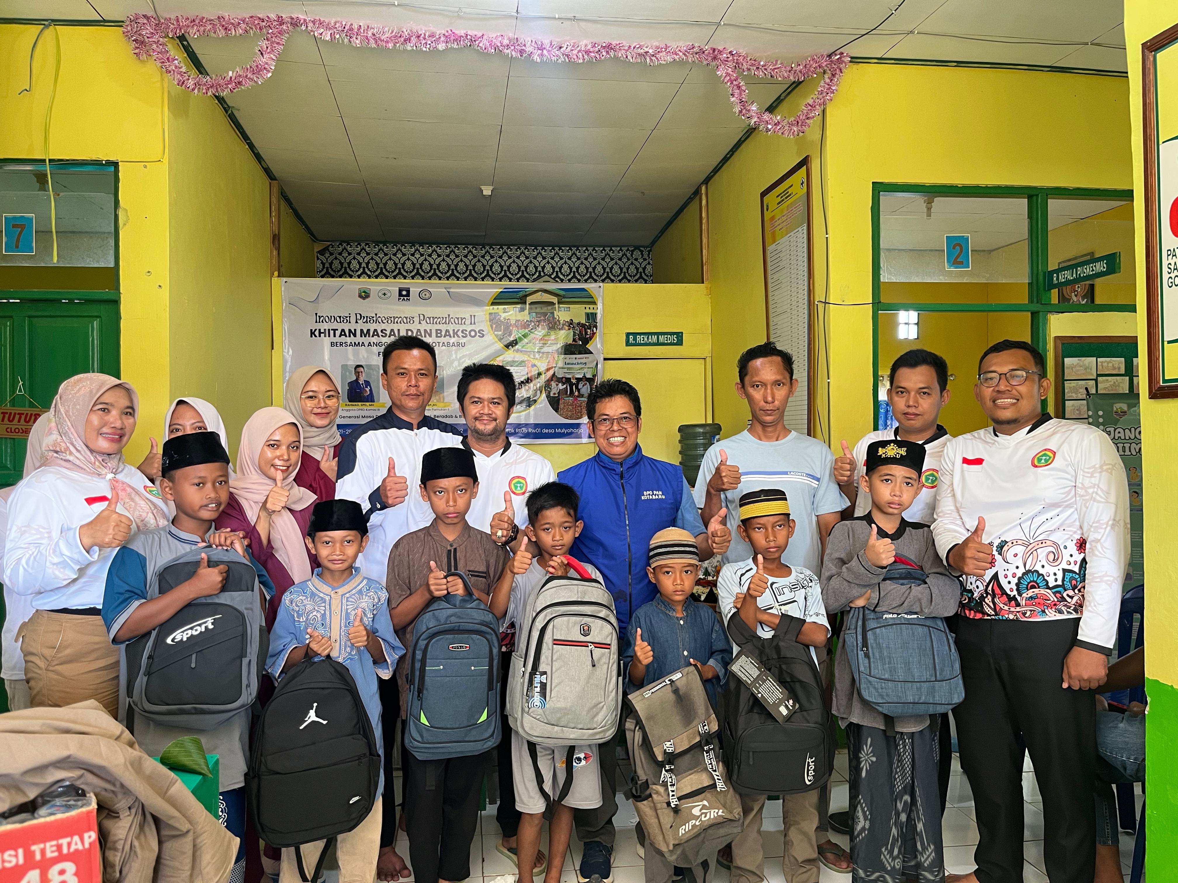 SENANG:Anggota DPRD Kotabaru, Rahmad beserta petugas Puskesmas Pamukan 2, dan anak-anak peserta sunatan massal foto bersama.