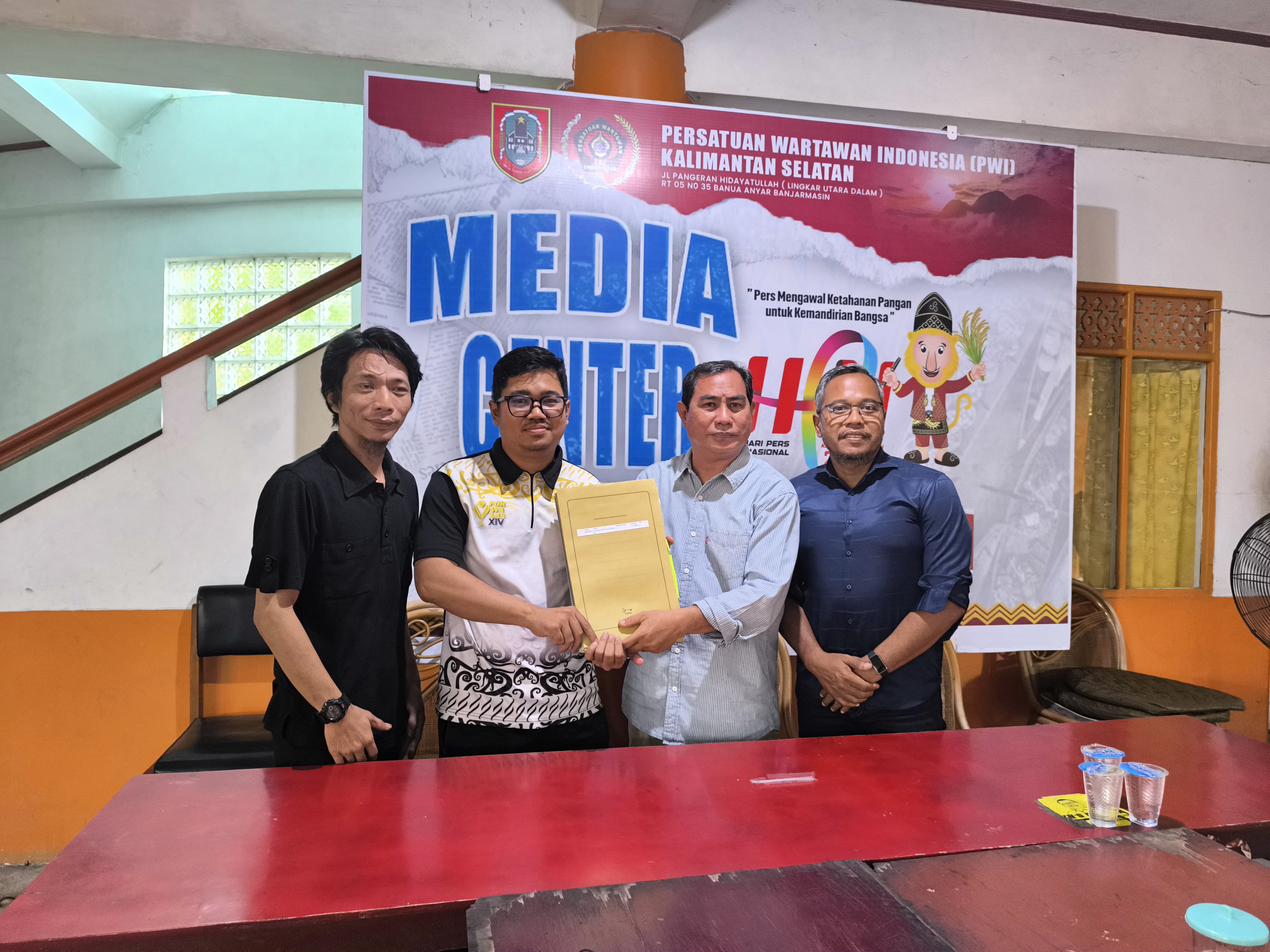 SERAHKAN DOKUMEN:Ketua PWI Kalsel, Zainal Helmie menerima berkas konferkab dari PWI Balangan, Senin (14/7/2025).(Foto:M Dirga/Radar Banjarmasin)