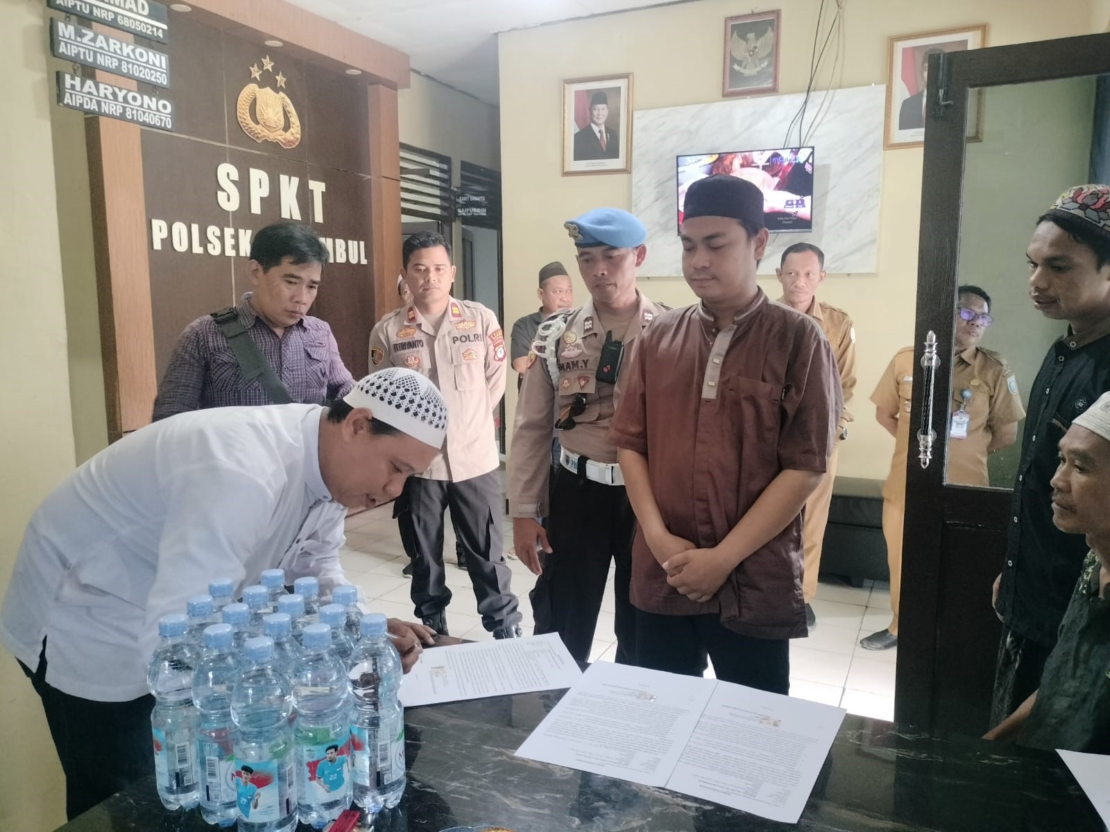 AKHIRI KASUS: Perwakilan pemerintah desa menandatangani kesepakatan penyelesaian kasus penilapan uang wakaf secara kekeluargaan di Polsek Astambul Senin (14/7/2025) (POLRES BANJAR)