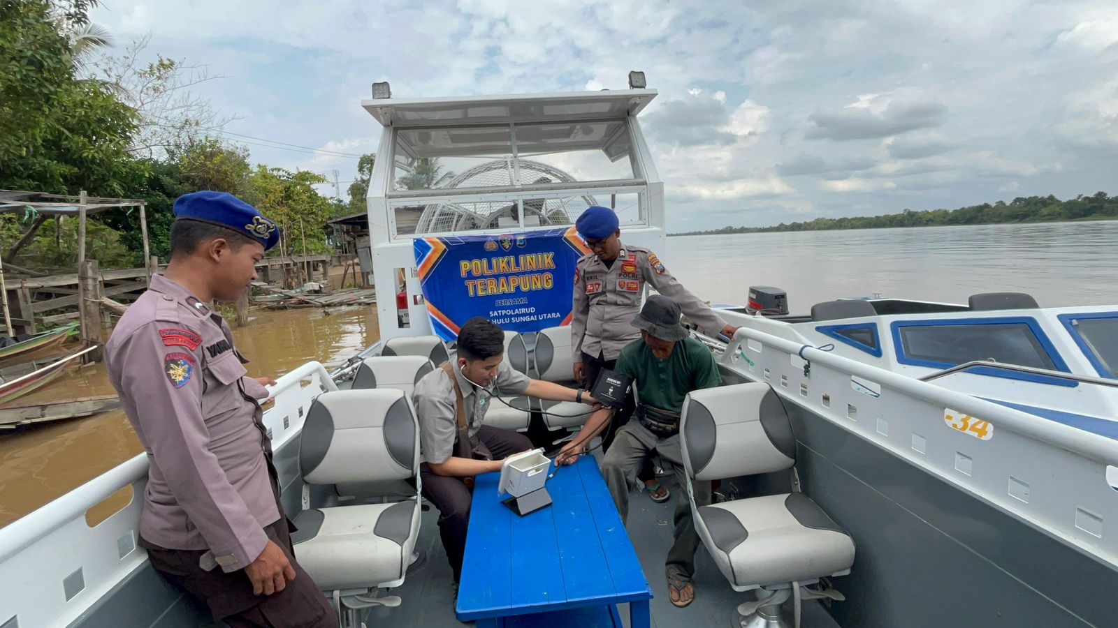 KEPEDULIAN: Anggota Polairud bersama tenaga kesehatan di Puskesmas Paminggir, Kabupaten HSU, gelar layanan kesehatan dengan klinik terapung, Senin (21/7/2025).