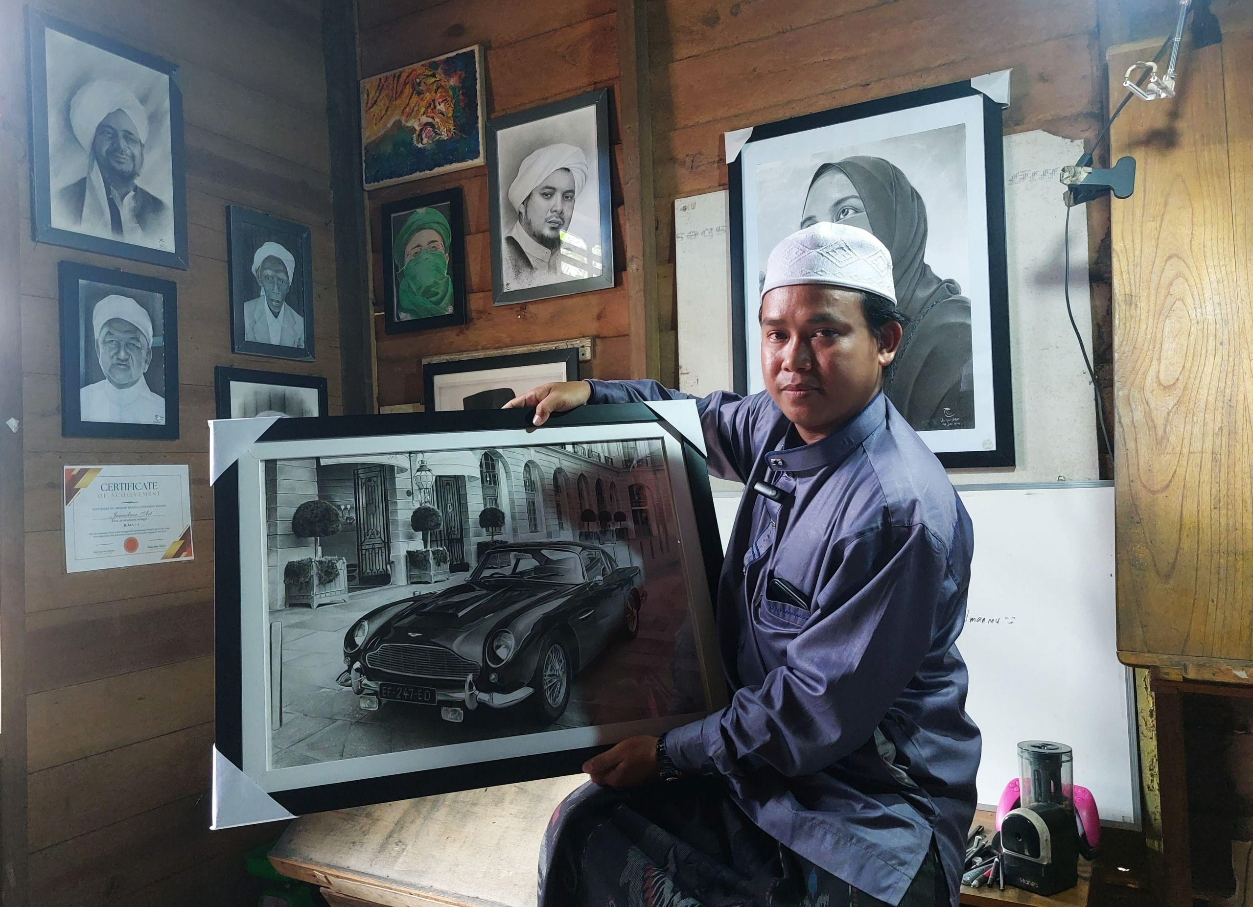KARYA: Ahmad Junaidnor (30) menunjukkan salah satu karya lukis terbaiknya saat ditemui penulis di kediamannya di Desa Hantakan, Hulu Sungai Tengah, Senin (14/7/2025).