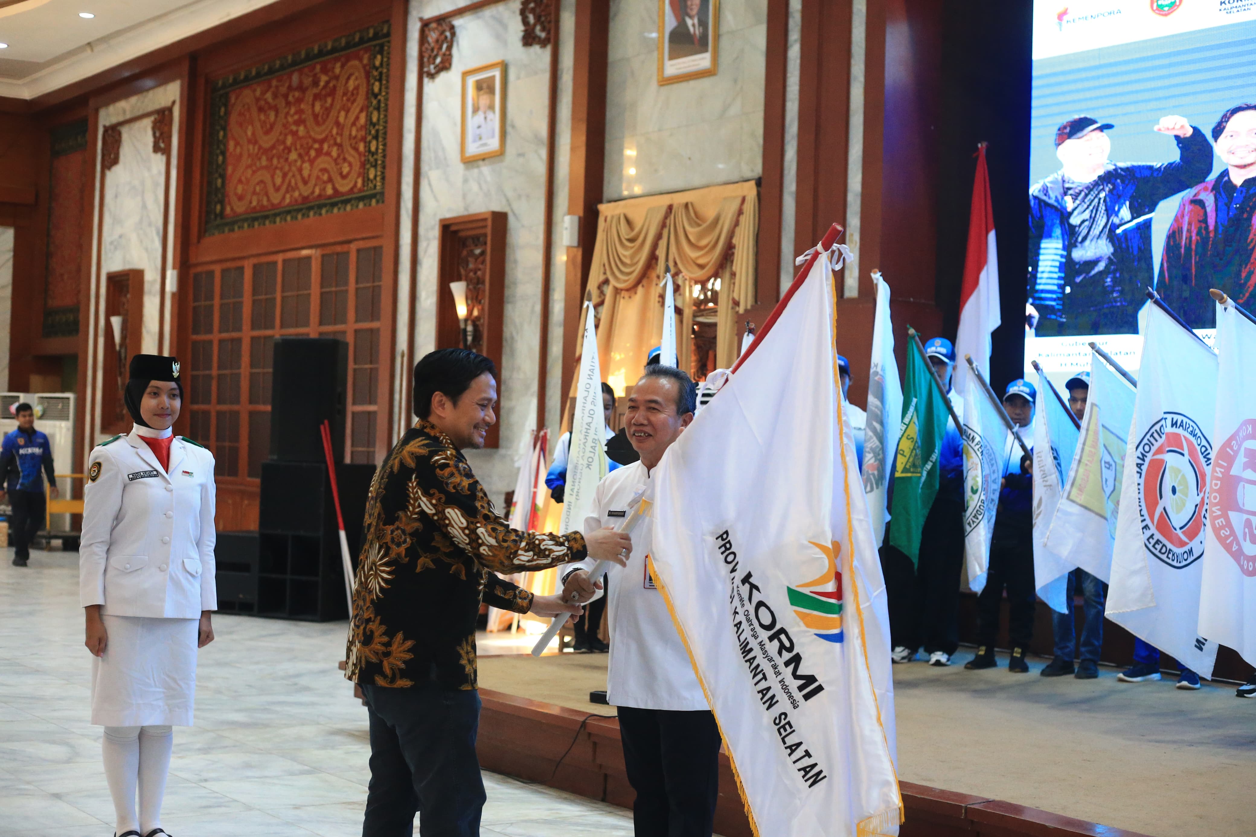 MELEPAS: Wakil Gubernur Kalsel Hasnuryadi Sulaiman menyerahkan bendera kepada Ketua KORMI Kalsel M. Syarifuddin, melepas kontingen KORMI yang akan berlaga di FORNAS VIII NTB 2025.