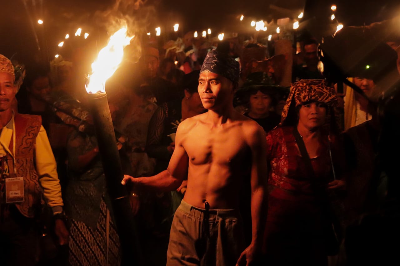 PENERANGAN OBOR:Warga Desa Liyu menampilkan kebudayaannya menyalakan obor di malam hari dalam perayaan Mesiwah Pare Gumboh.