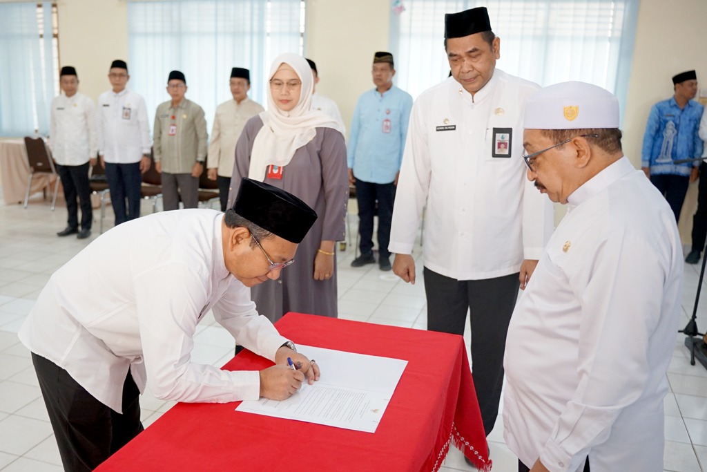 LEGAWA: Mokhamad Hilman menandatangani berkas pelantikannya sebagai Staf Ahli Bidang Ekonomi, Pembangunan dan Keuangan Kabupaten Banjar, Jumat (25/7/2025).