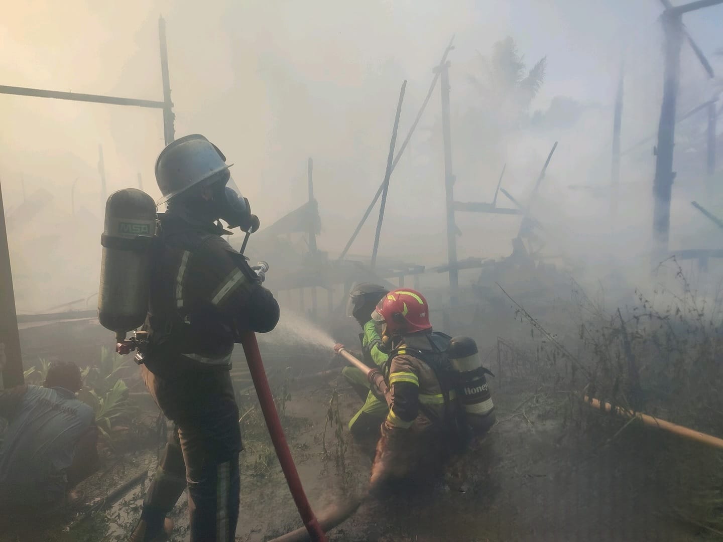 BERJIBAKU: Petugas Damkar bersama relawan berjibaku memadamkan api yang melalap rumah warga di Desa Kaliukan, Kecamatan Astambul, Kabupaten Banjar, Jumat (25/7/2025).