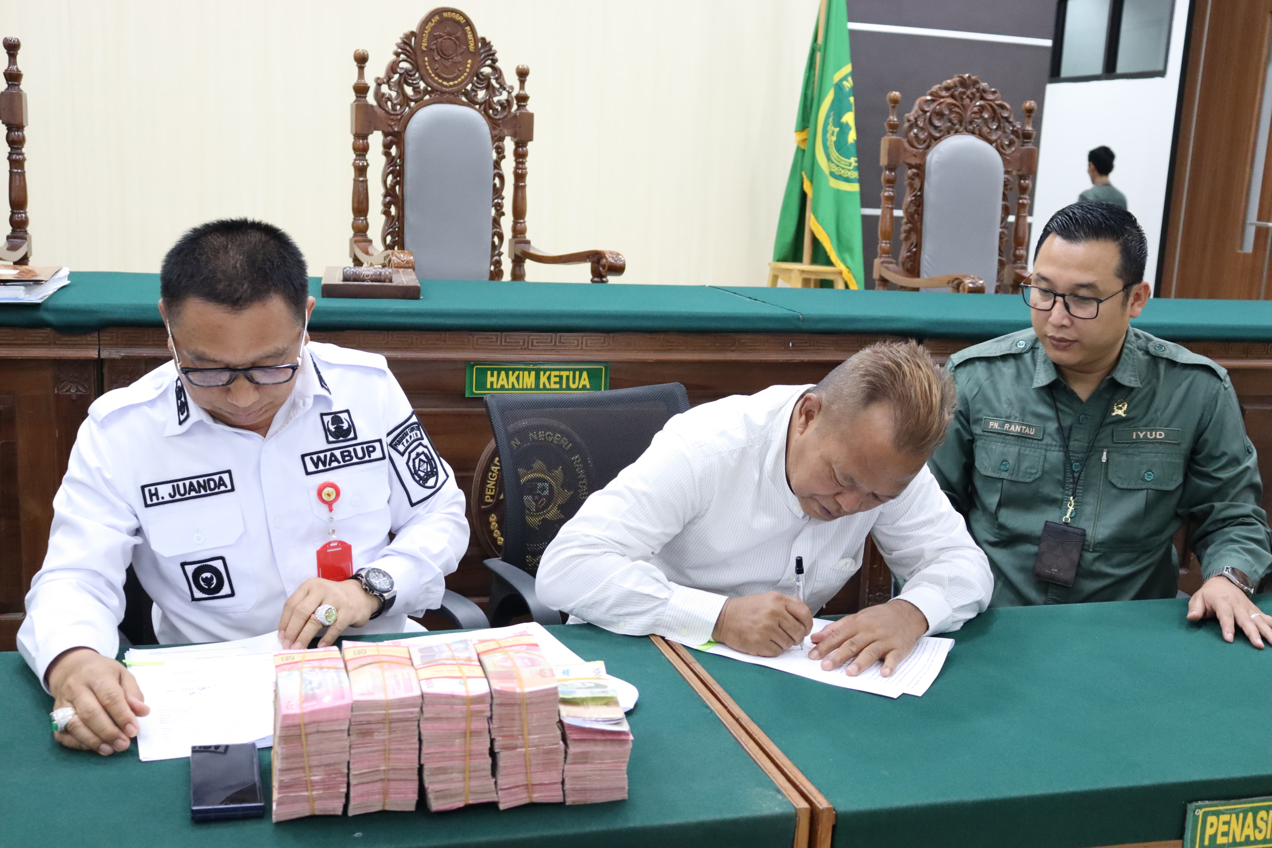 BERAKHIR DAMAI: Wakil Bupati Tapin H Juanda menandatangani berkas bersama ahli waris, usai sengketa tanah berakhir damai.