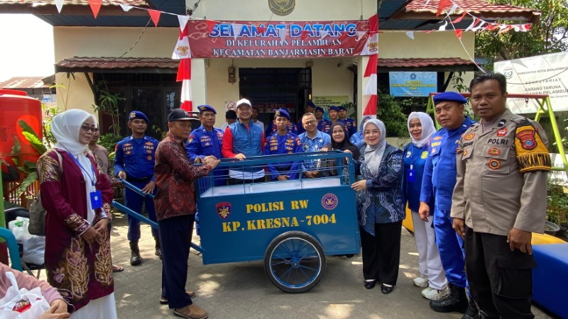 BANTUAN: Anggota Baharkam Polri memberikan gerobak sampah untuk warga  Pelambuan, Banjarmasin Barat.