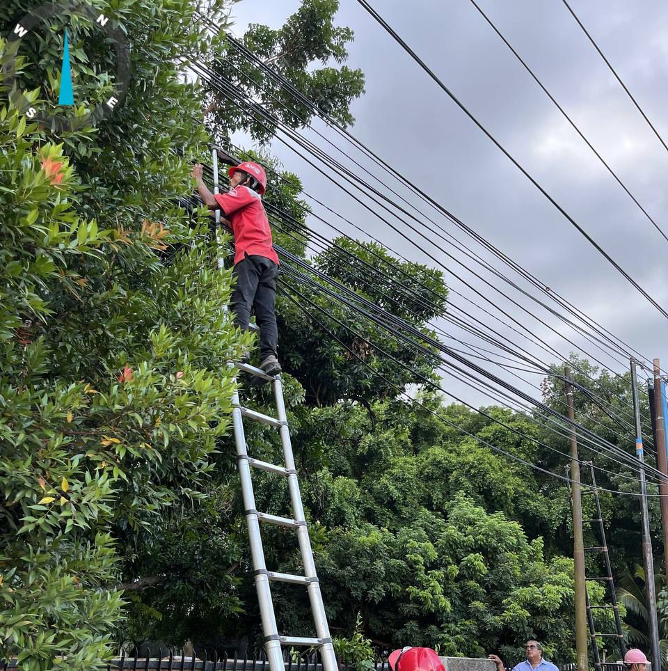 MERAPIKAN: Petugas saat merapikan kabel semrawut di Banjarbaru.