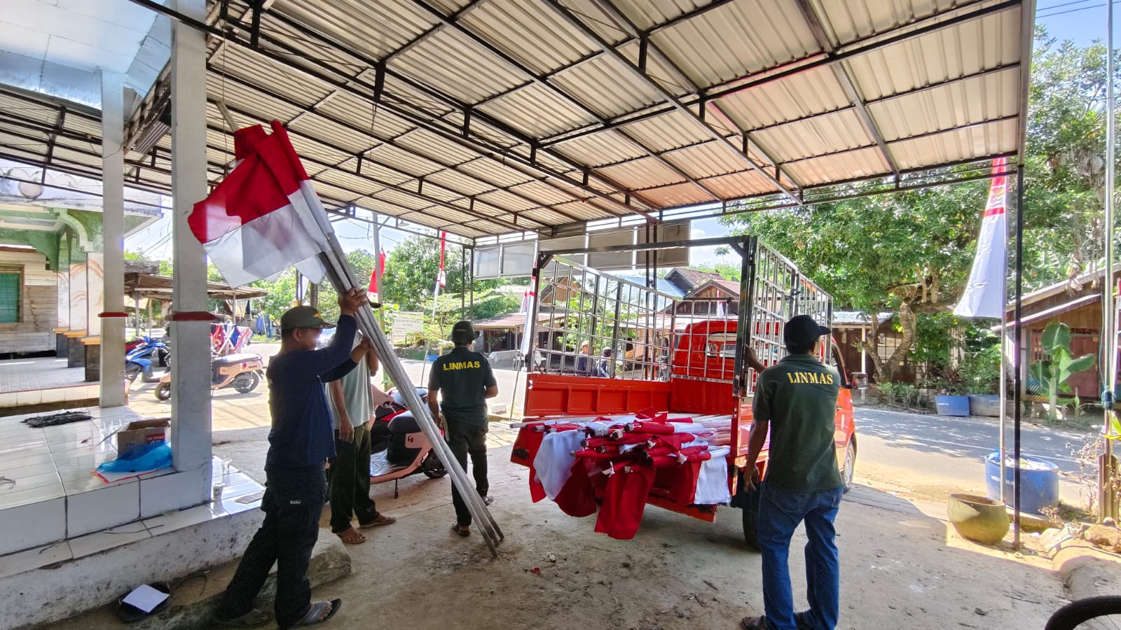 SEMARAK: Pemdes Balida, Kecamatan Paringin, Kabupaten Balangan dan Linmas gotong royong memasang bendera dan umbul-umbul di lingkungan desa.