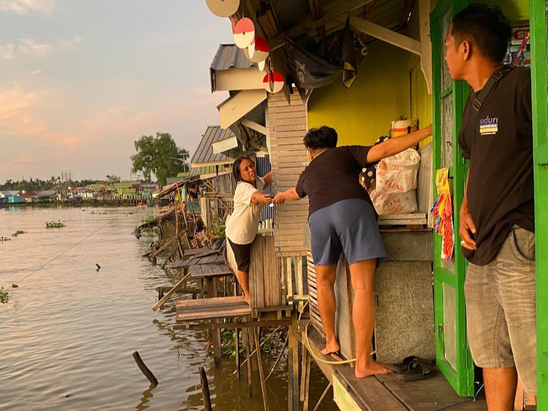 JANGKAU: Warga Kampung Hijau saling jangkau satu sama lain untuk menyelematkan barang berharga.