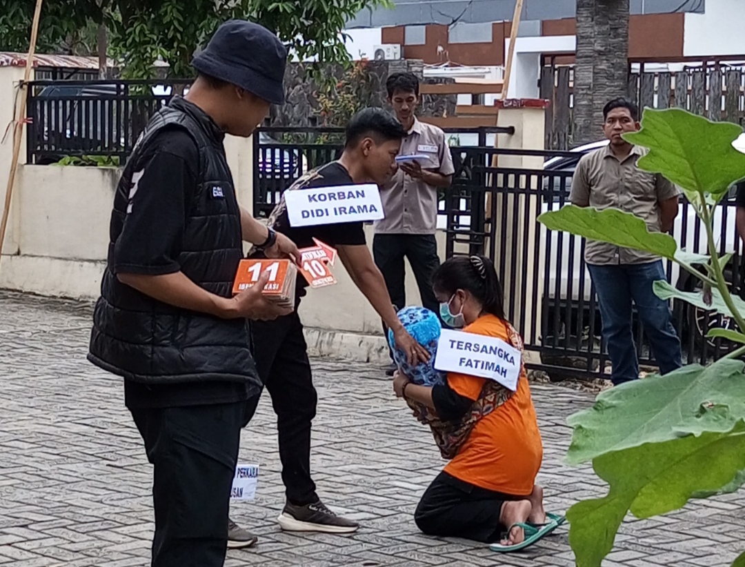 REKONSTRUKSI: Dua tersangka kakak beradik memperagakan 43 adegan kasus istri mutilasi suami di Paramasan Atas saat rekonstruksi di halaman Polres Banjar, Kamis (7/8/2025).