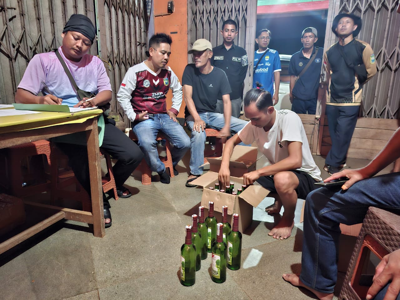 LICIK : Kepala Satpol PP dan Damkar Tala bersama pihak terkait mengamankan puluhan botol miras dari salah satu warga di Desa Kintapura, Jumat (8/8/2025). (Foto : Satpol PP dan Damkar Tala untuk Radar