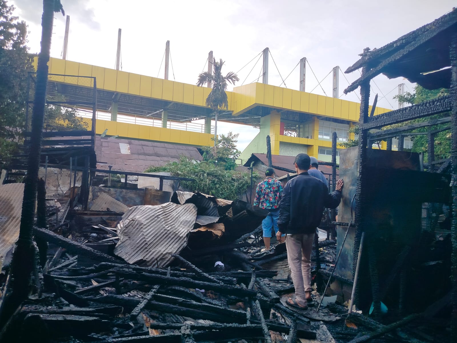 SISAKAN PUING: Pihak keluarga rumah eks asrama TNI di depan Stadion 17 Mei Banjarmasin terlihat mencari sesuatu di sisa kebakaran.