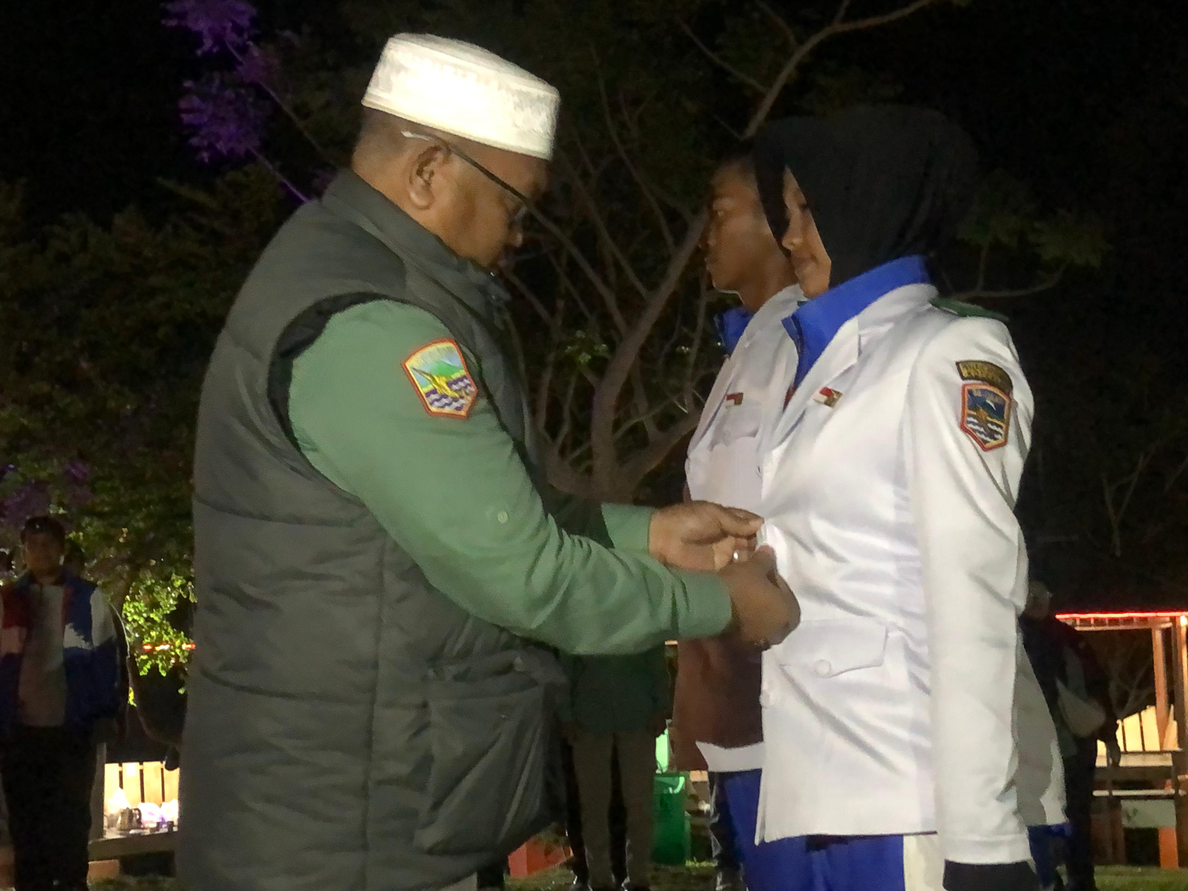 DISEMATKAN: Kepala Kesbangpol Kotabaru Akhmad Rajudinoor menyematkan baju PDU Paskibra kepada perwakilan Capaskibra Kotabaru 2025.