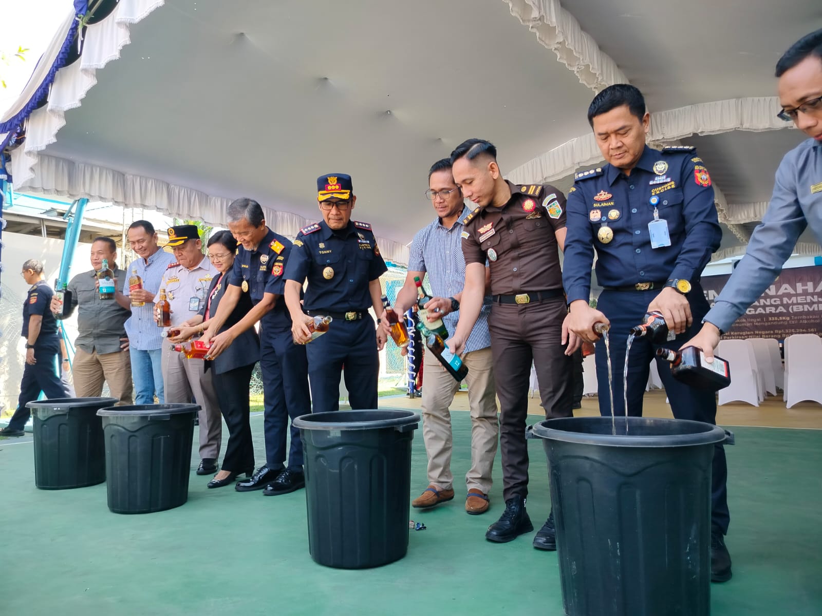 DIMUSNAHKAN:Sejumlah botolan minuman keras illegal ditumpahkan dalam ember besar.//maulana