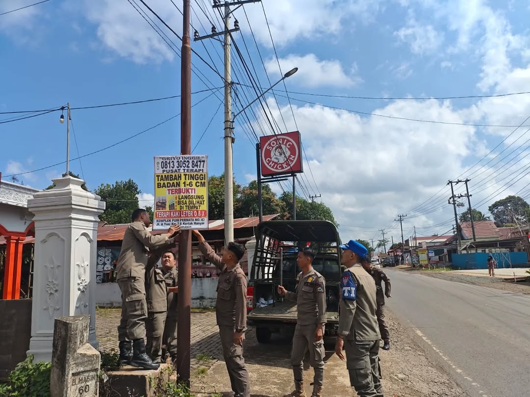 MENGGANGGU : Personel Satpol PP dan Damkar Tala saat menertibkan sejumlah spandul atau reklame liar di Kota Pelaihari.