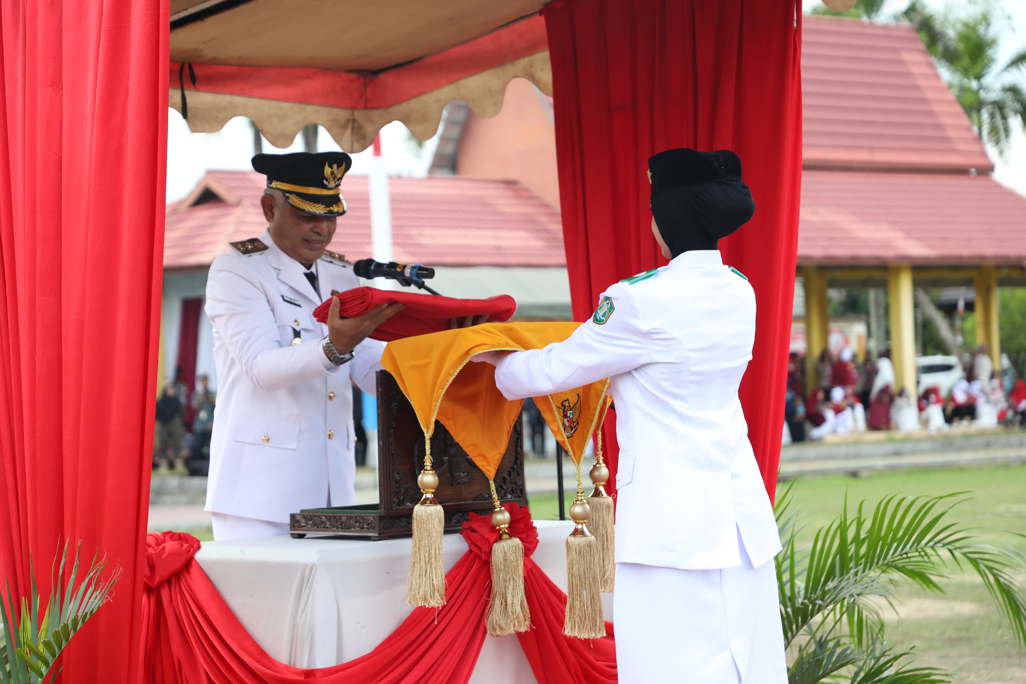MOMEN:Wakil Bupati HSU, Hero Setiawan menerima bendera merah dari pembawa baki paskibraka di upacara penurunan bendera di Lapangan Pahlawan Amuntai, Minggu (17/8/2025).