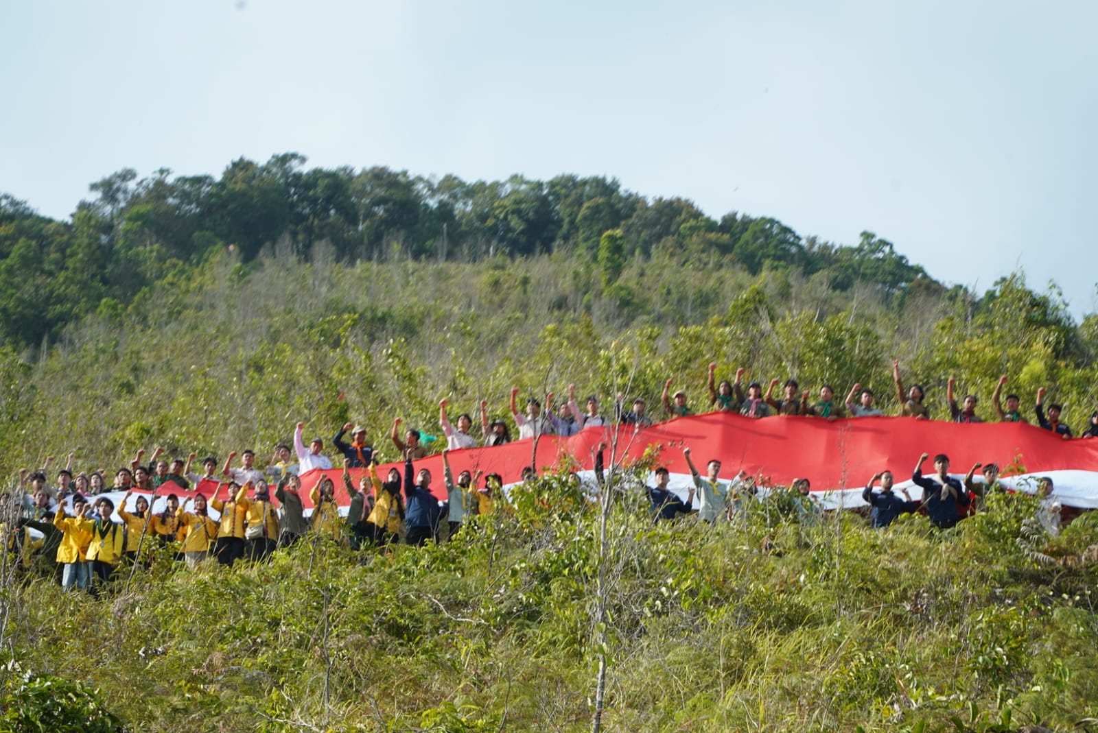 BENDERA: Wakil Rektor Bidang Kemahasiswaan dan Alumni ULM Dr M Rusmin Nuryadin bersama mahasiswa dan dosen membentangkan bendera merah putih di Hutan Pendidikan KHDTK ULM usai upacara kemerdekaan.