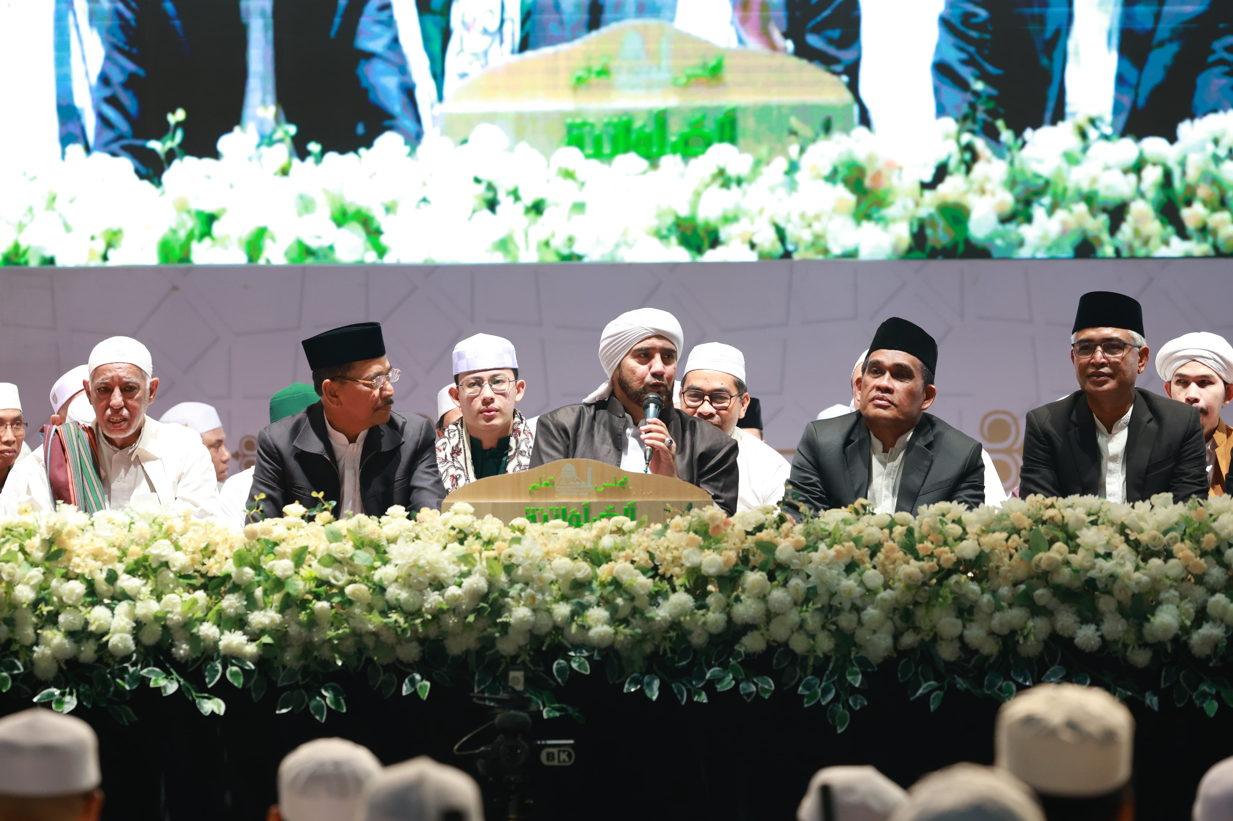 MOMEN:Habib Syech bin Abdul Qodir Assegaf saat memimpin HSU Bersalawat di Lapangan Pahlawan Amuntai, Minggu (24/8/2025), didampingi Bupati HSU, H Sahrujani (dua kanan).