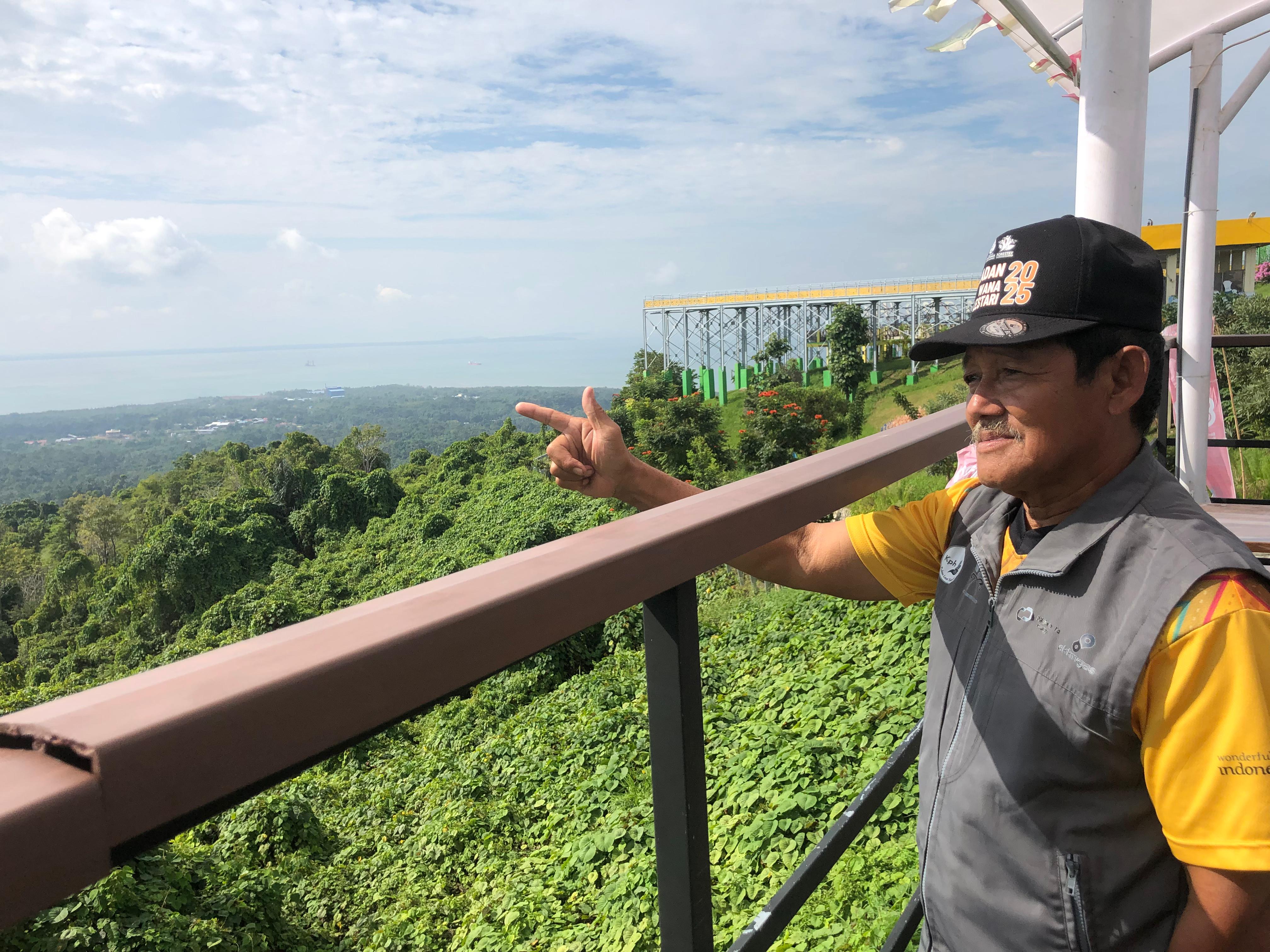BIKIN BANGGA: Abdul Mulut atau Kai Oyong, (65), warga sedang melihat pemandangan di Bukit Mamake. Foto: Jumain/ Radar Banjarmasin.