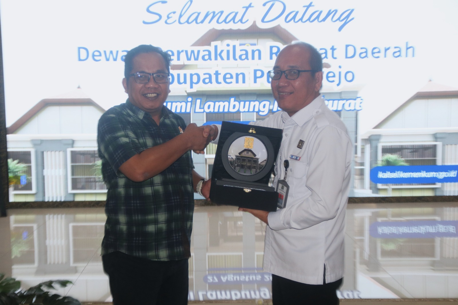 STUDI BANDING:Kepala Kanwil Kemenkum Kalsel, Alex Cosmas Pinem (kanan) menjabat tangan Ketua Komisi I DPRD Kabupaten Purworejo, Budi Sunaryo, Rabu (27/8/2025).