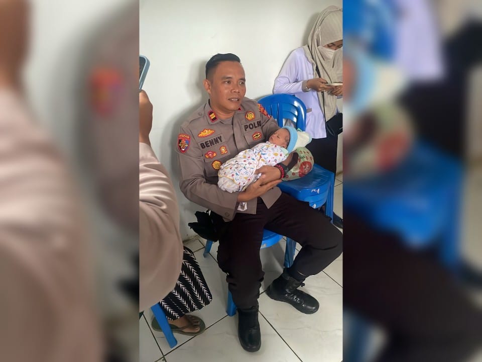 GEGER: Kapolsek Pelaihari Iptu Benny Wisnhu Wadhany menggendong bayi laki-laki yang ditemukan di Jalan PT Sun Pelaihari.