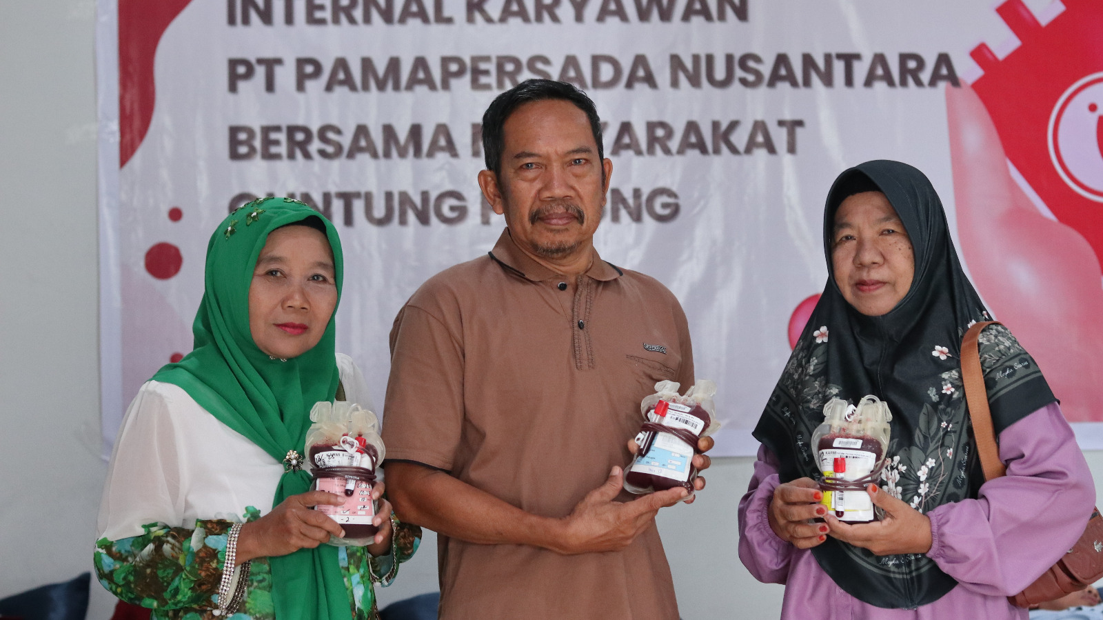 Masyarakat sekitar menunjukkan kantong darah hasil donor dalam kegiatan donor darah PAMA BBSO di Kelurahan Guntung Manggis
