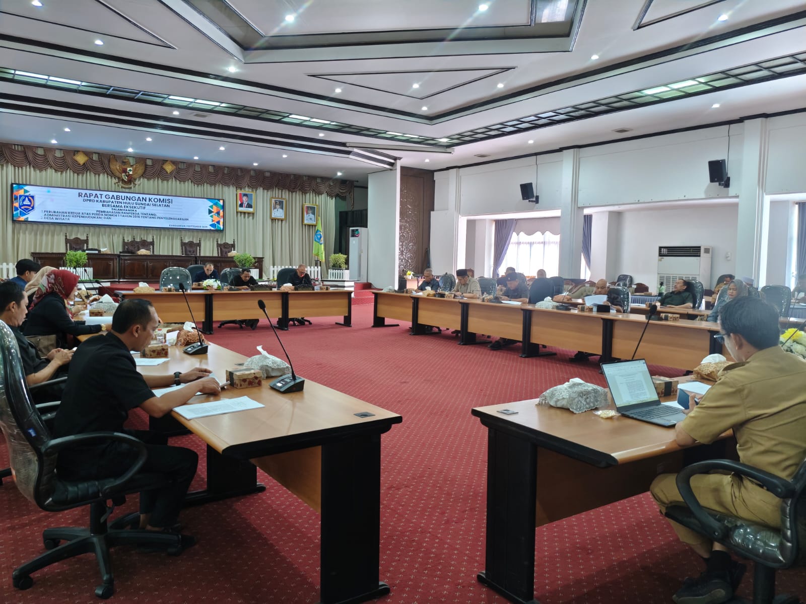 RAPAT:Wakil Ketua II dan I DPRD HSS, Muhammad Kusasi dan Husnan memimpin rapat gabungan komisi membahas perubahan kedua atas Perda nomor satu 2010 tentang penyelenggaraan administrasi kependudukan.