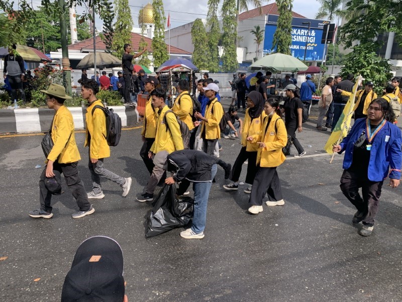 DAMAI:&nbsp;Seorang mahasiswa memungut botol plastik yang berserakan di Jalan Lambung Mangkurat, Banjarmasin Tengah, usai demonstrasi pada Senin (1/9) siang.